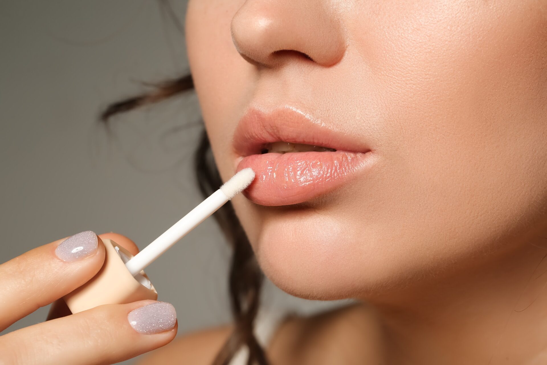 A woman with a lip brush in her mouth