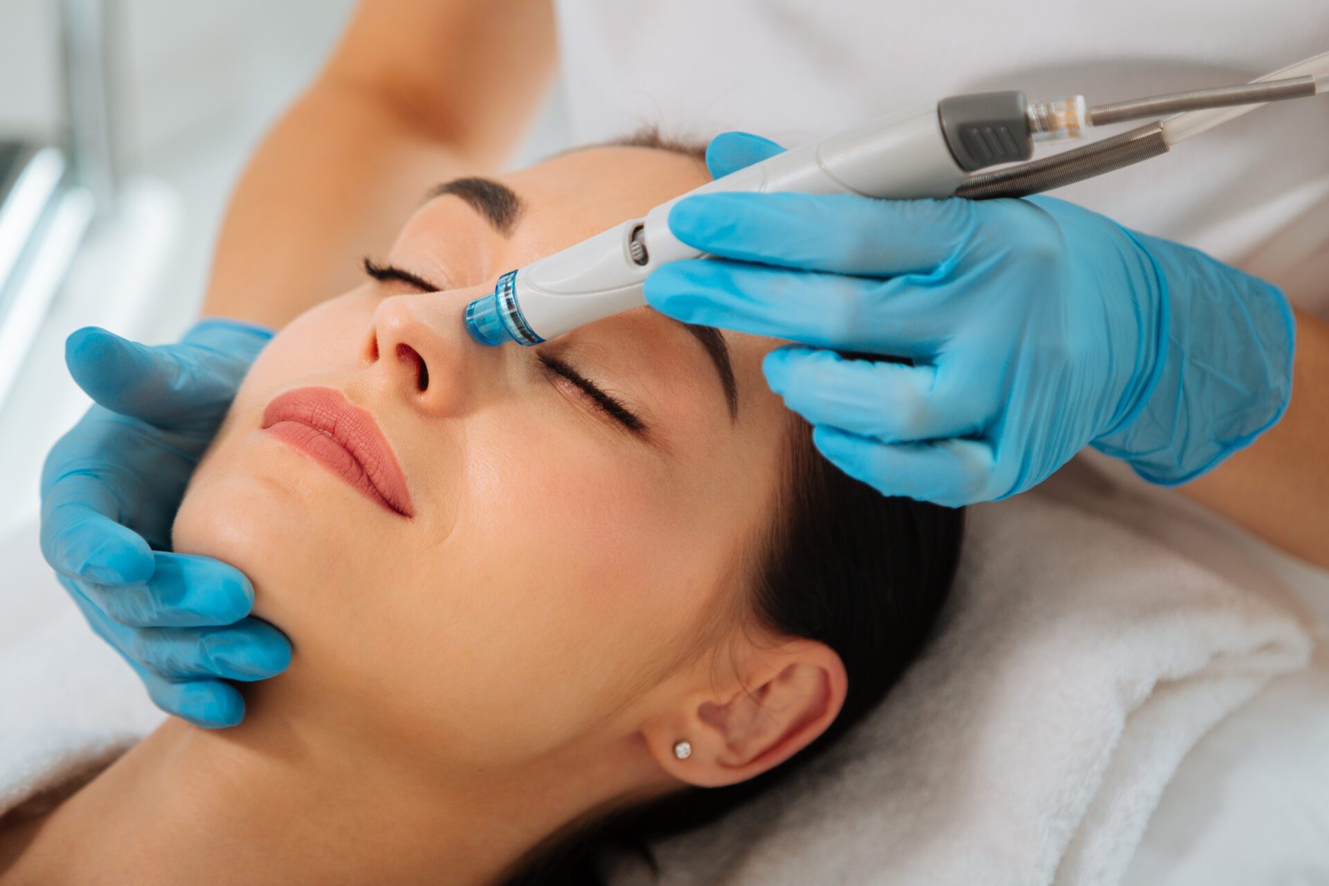 Facial procedure. Delighted nice woman lying on the medical bed with her eyes closed while having hydrafacial