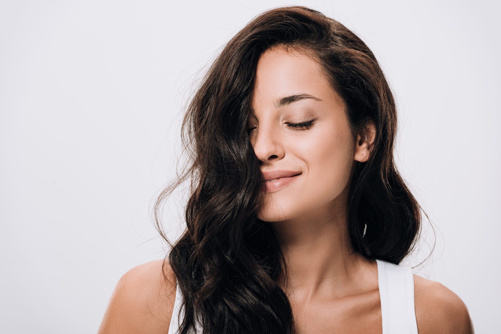 A woman with her eyes closed and her hair blowing in the wind