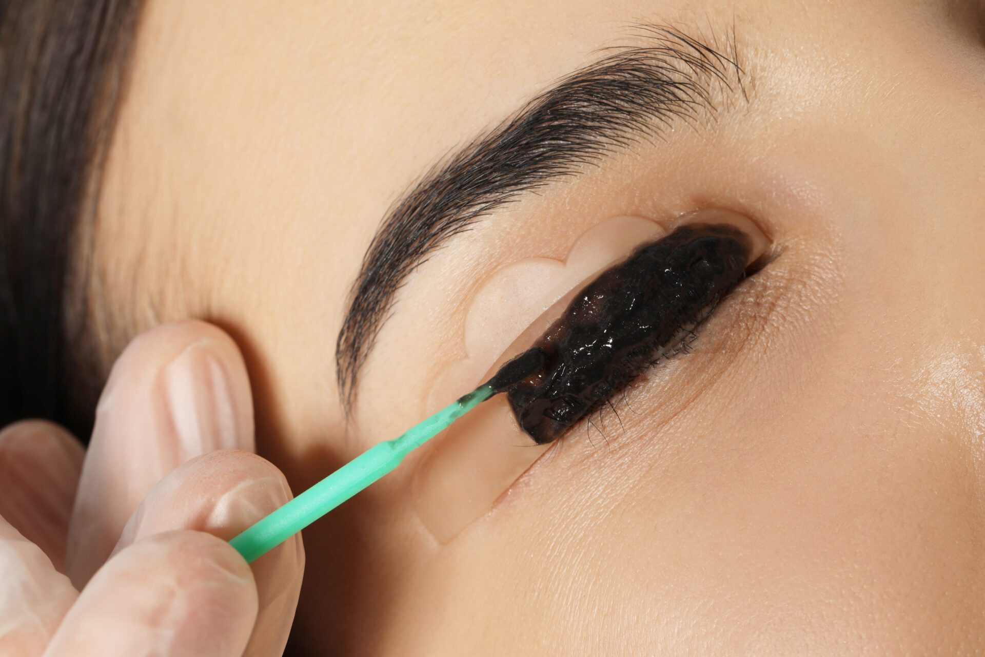 Young woman undergoing eyelash lamination and tinting